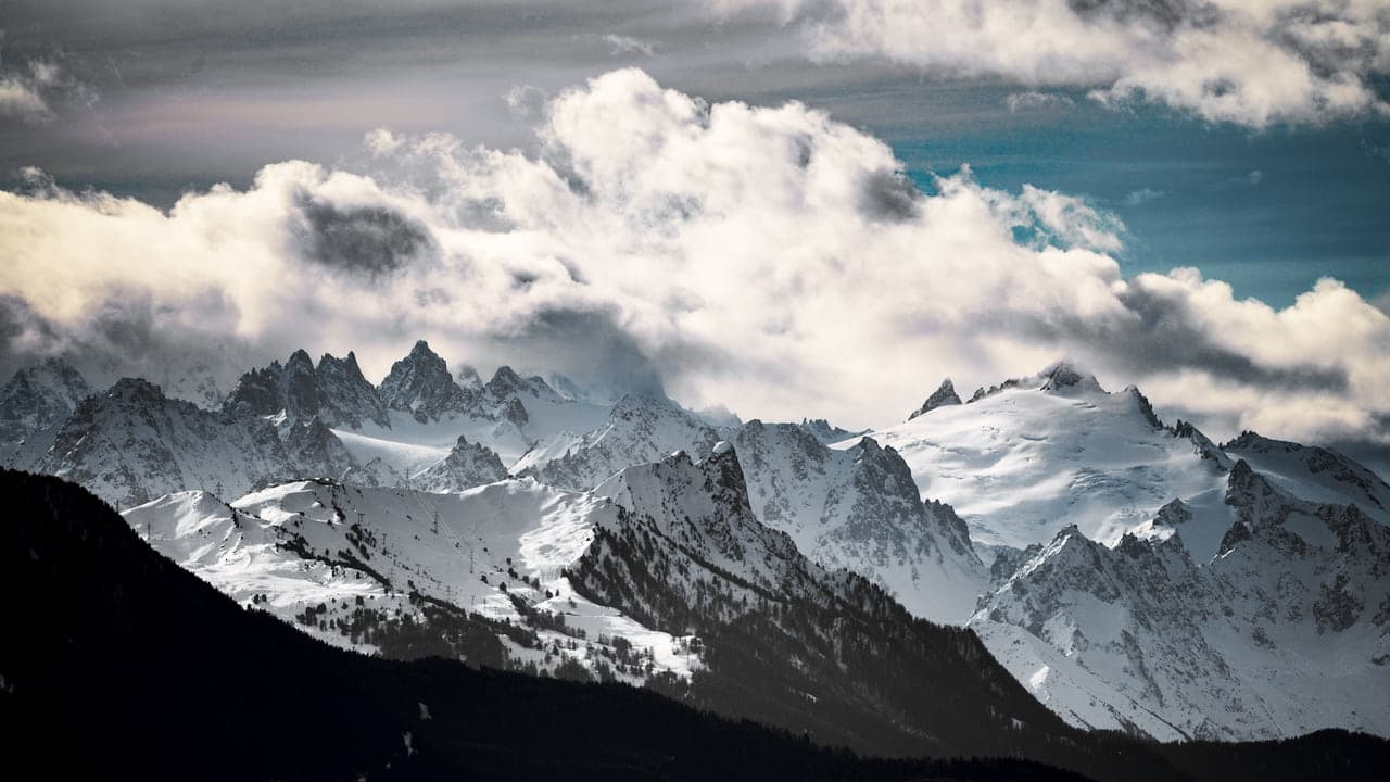 Jagged Dolomite peaks rising clear above a valley full of cloud