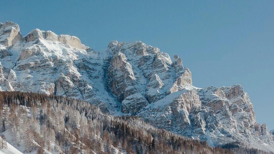 Snow covered Dolomite peaks above the forest near Cortina