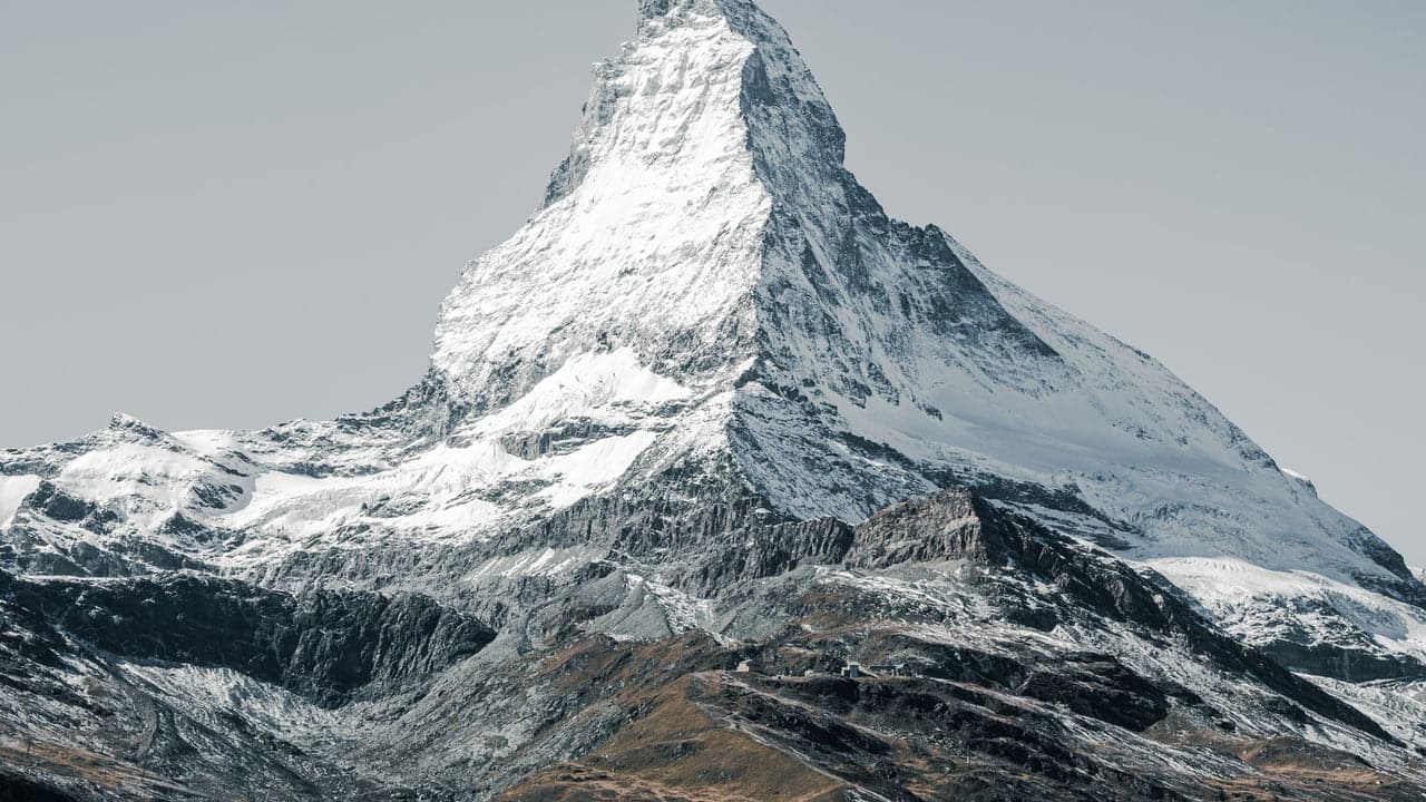 The snow-covered pyramid of the Matterhorn rising above bare rock, no other peaks in view